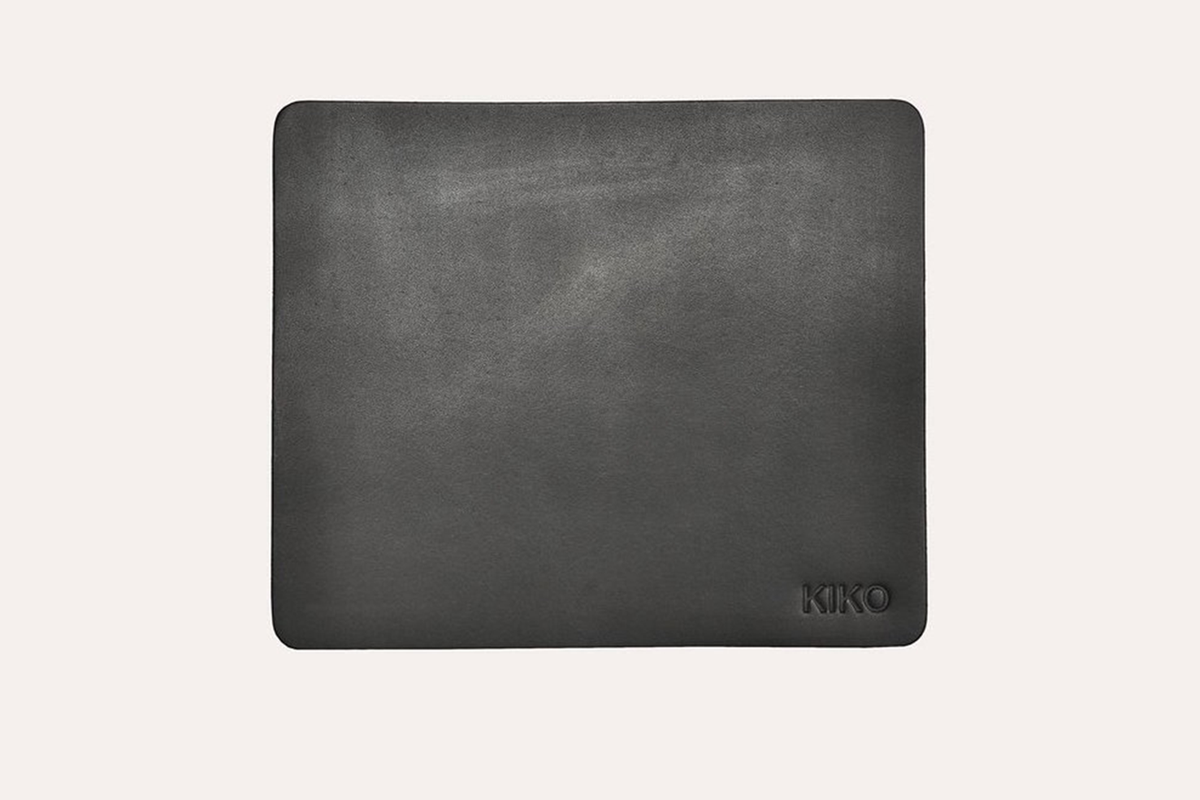 Tapis de souris en cuir gris foncé, surface mate, logo KIKO discret en bas à droite.
