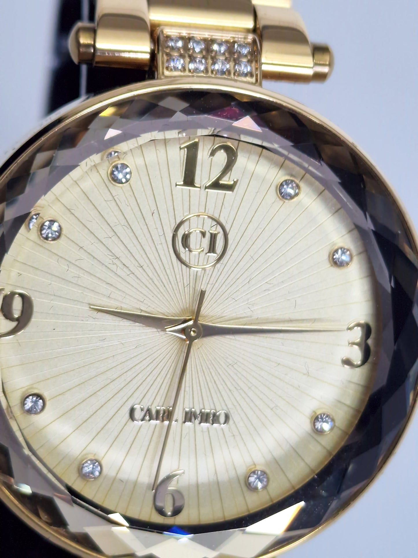 Montre femme cadran ivoire avec incrustations autour du verre et logo central.