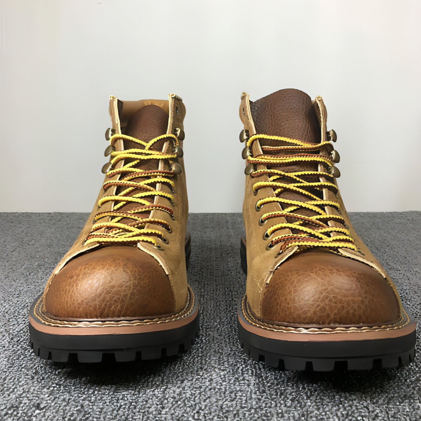Bottes en cuir marron à lacets jaunes, bout rond et semelle noire crantée