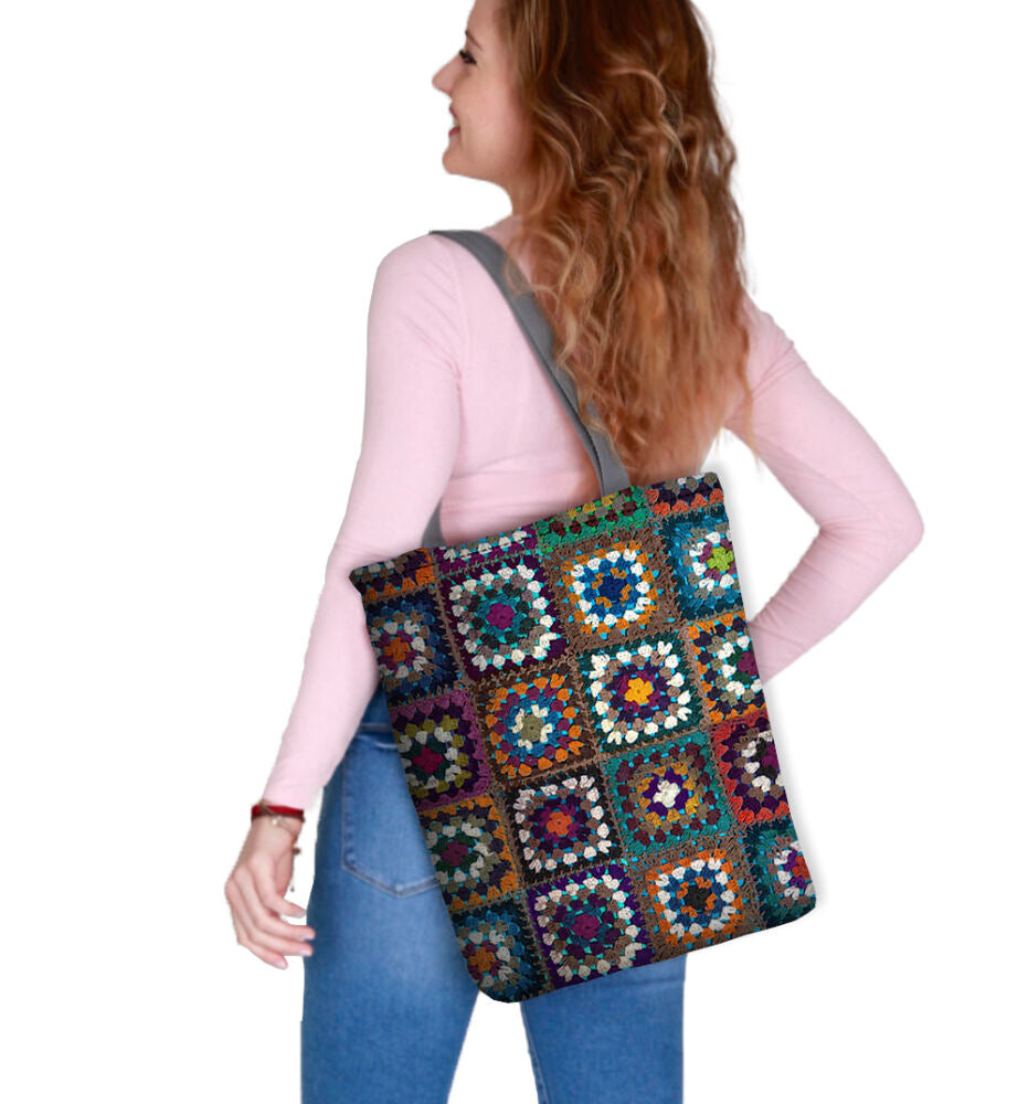Sac cabas patchwork multicolore porté à l’épaule, anses noires.