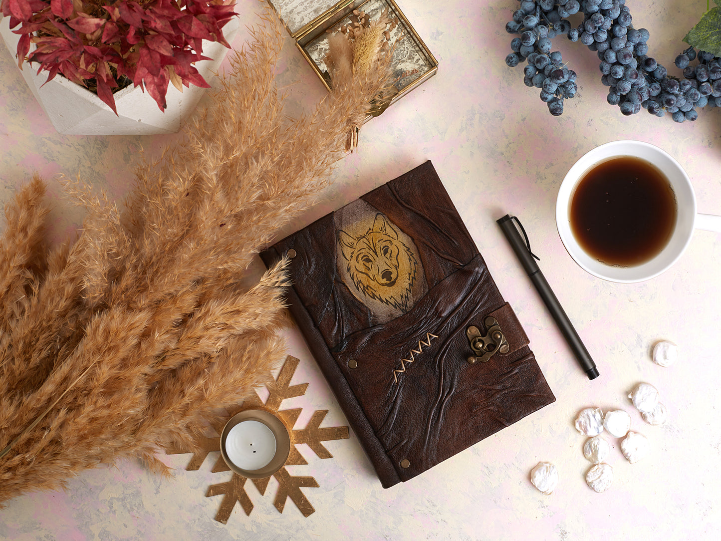 Journal en cuir brun motif loup doré, surpiqûres et fermeture, posé sur table