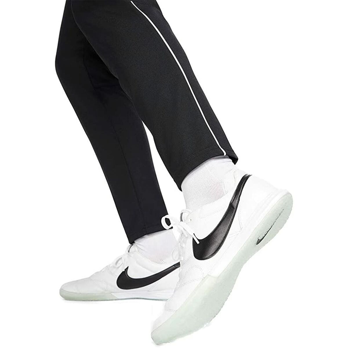 Pantalon noir avec passepoil clair sur la jambe et bas resserré.