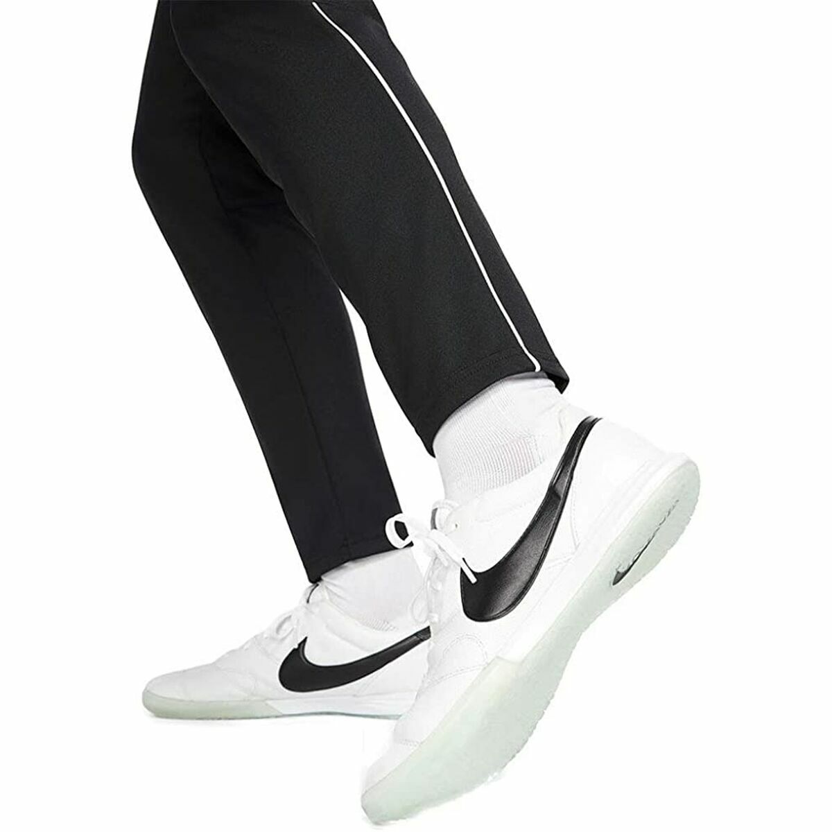 Pantalon noir de survêtement avec passepoil clair et baskets blanches