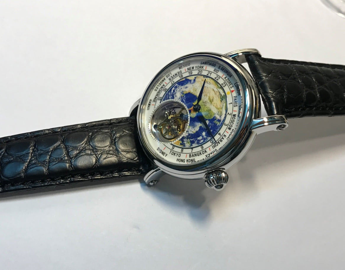 Montre homme cadran globe bleu, boîtier métal rond, bracelet cuir noir texturé