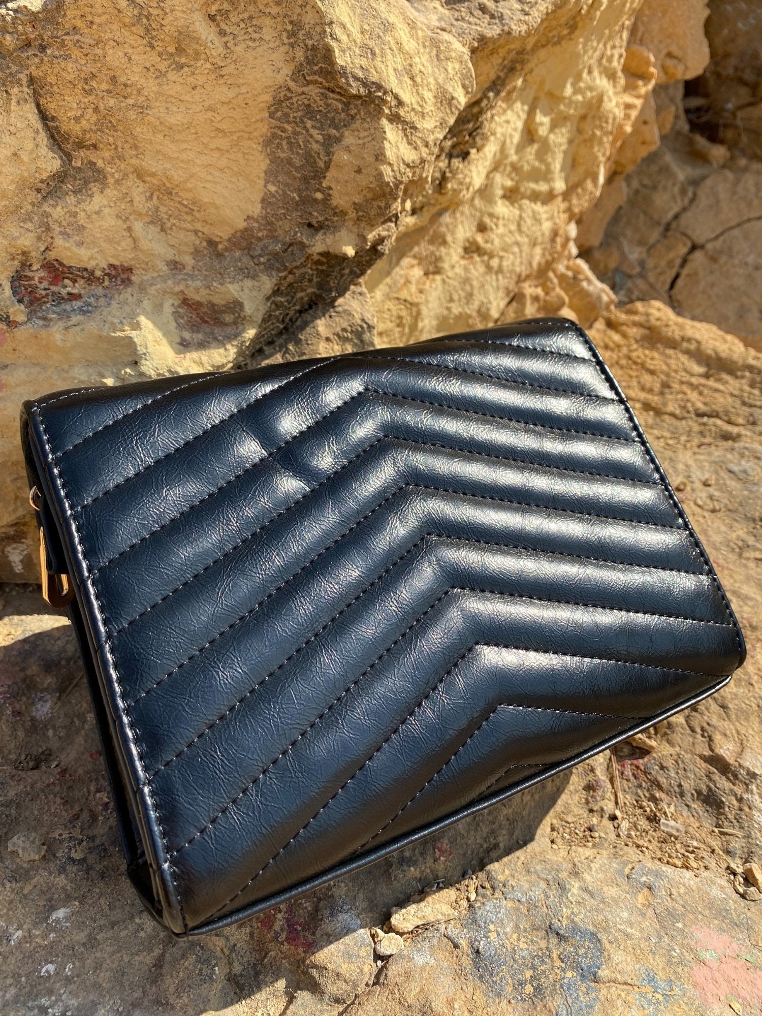 Sac bandoulière matelassé sombre, motif chevrons, fermoir métal