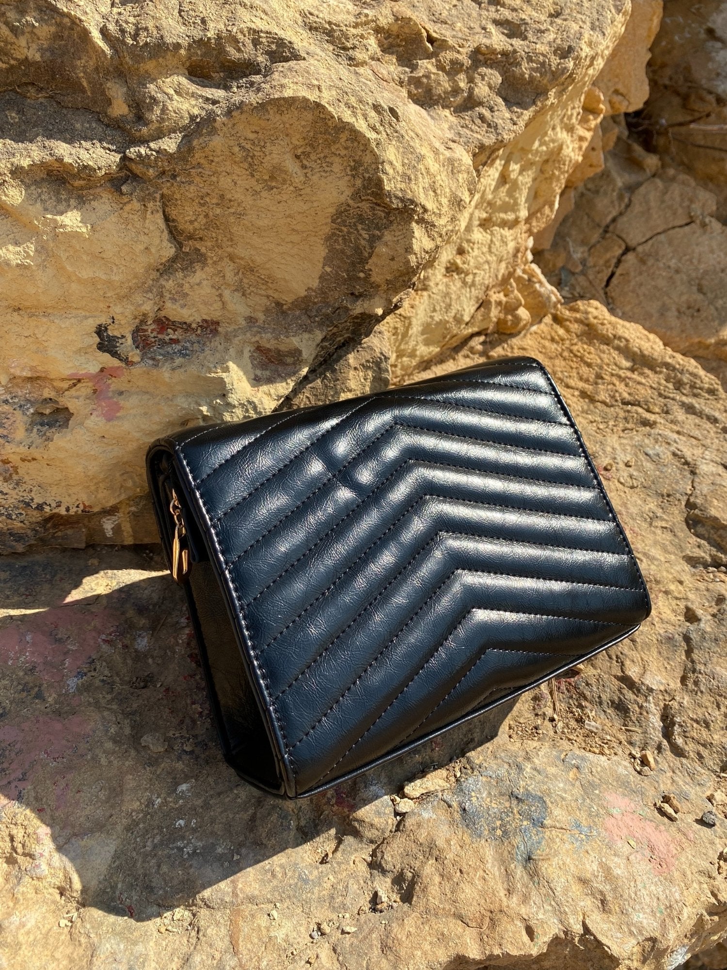 Sac bandoulière matelassé foncé, motif chevrons, fermoir métal, vue en biais