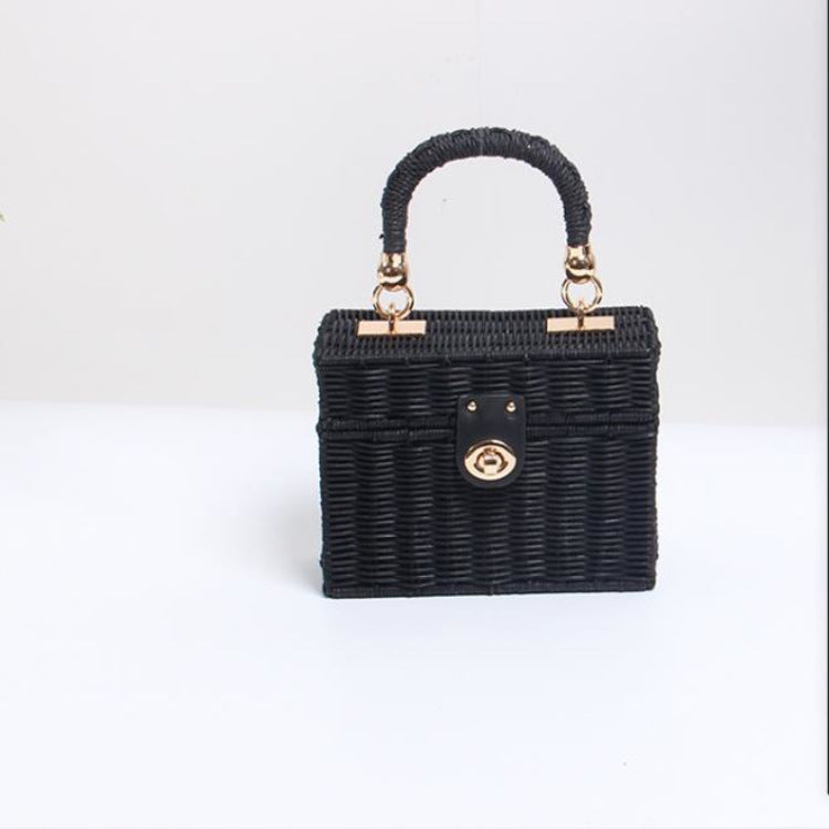 Sac boîte en raphia noir tressé, poignées bouclées dorées et fermoir central.