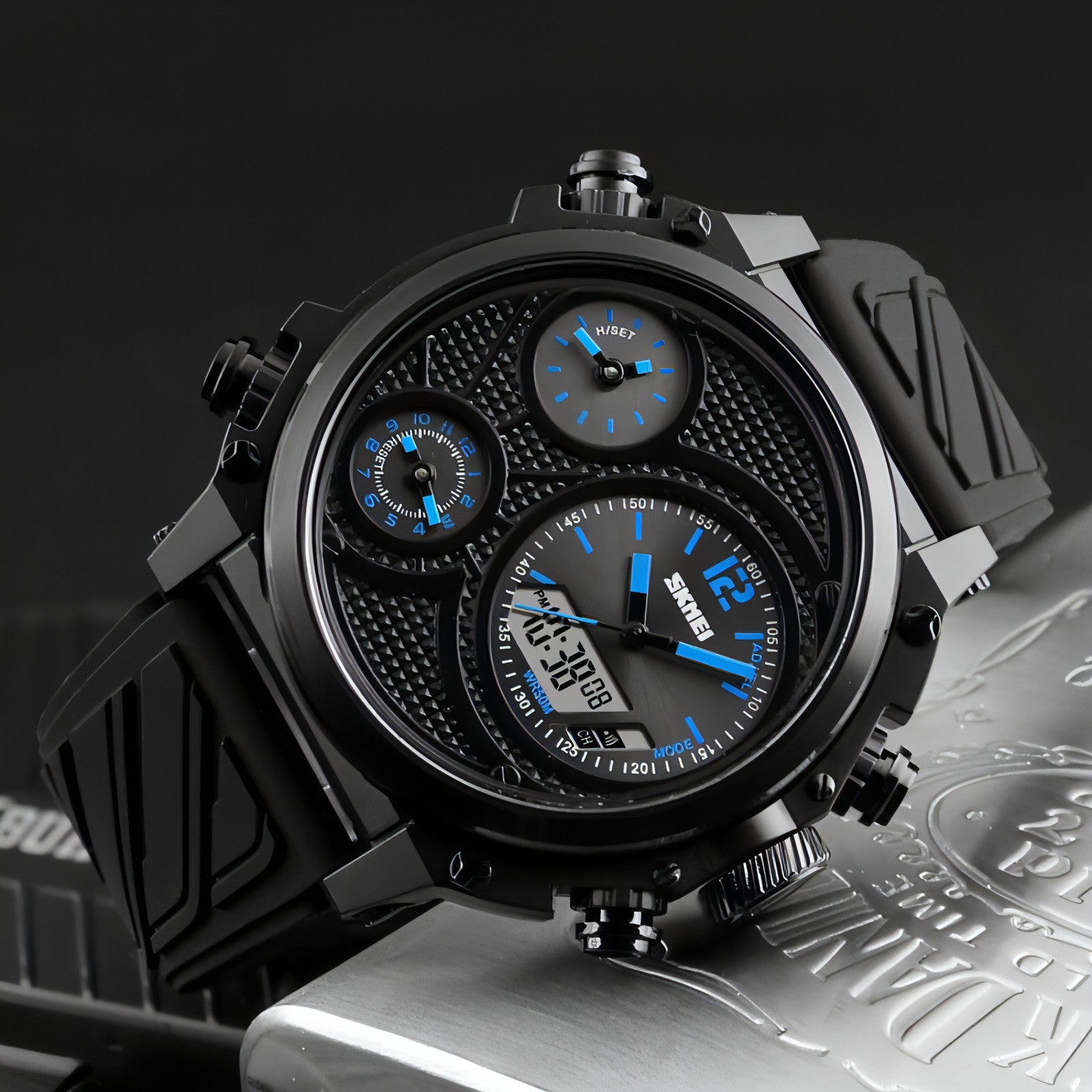 Montre multifonction noire, cadran noir avec compteurs bleus et boutons latéraux.