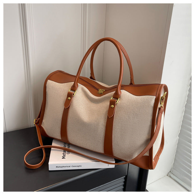Sac cabas de voyage en toile bicolore avec bandoulière et logo métallique sur le devant