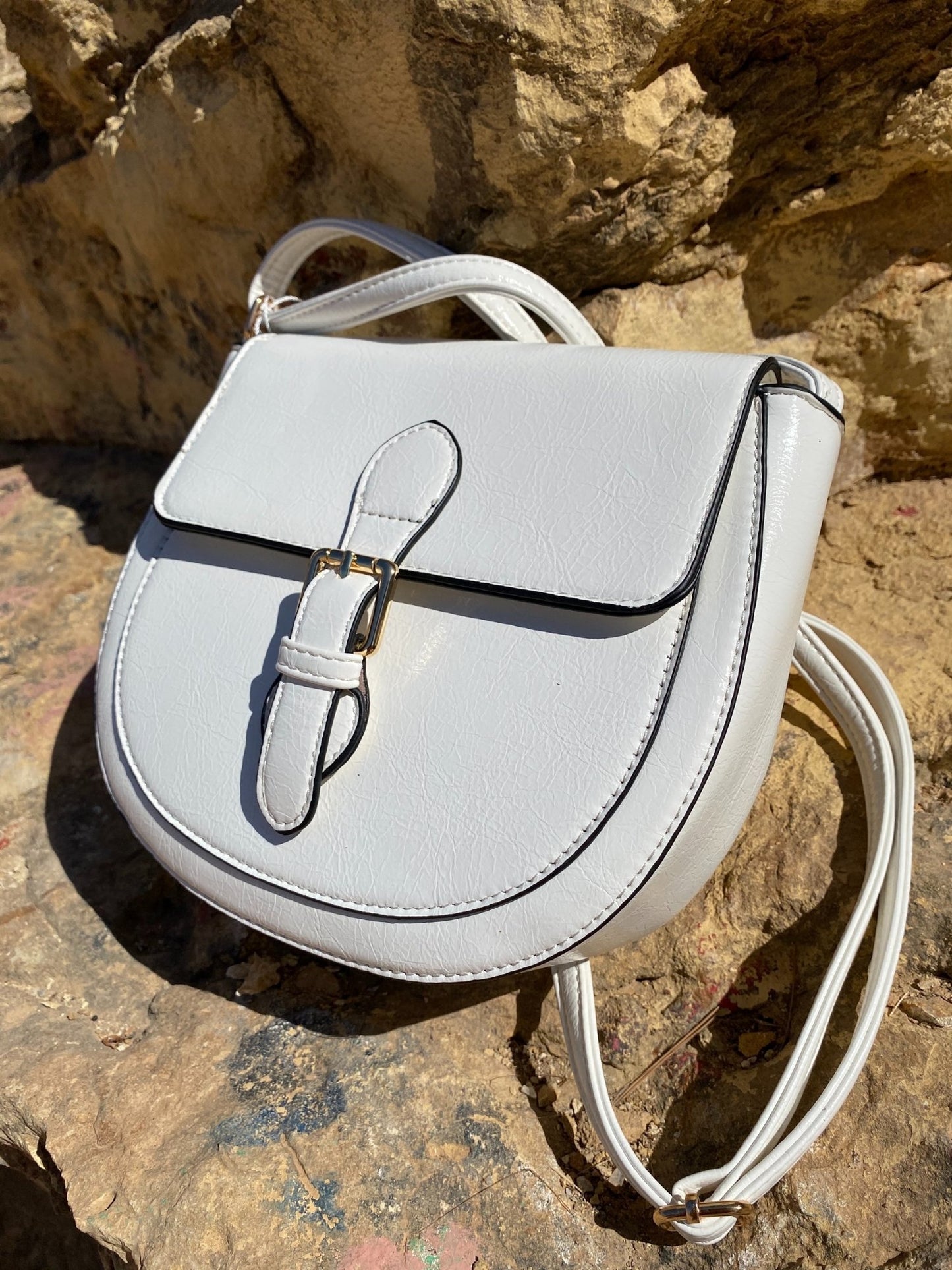 Mini sac à boucle blanc en simili cuir, bandoulière et fermoir métallique doré.