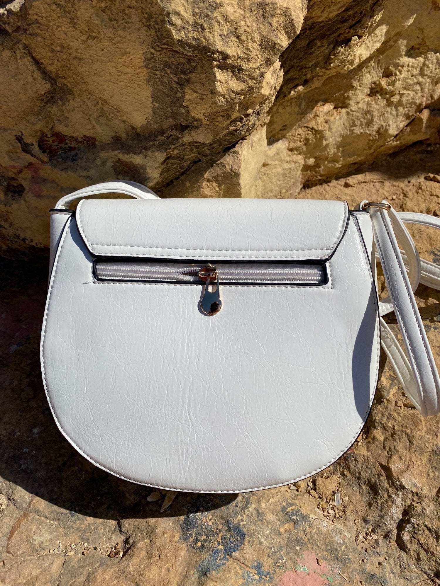 Mini sac à boucle blanc en simili cuir, rabat et détail de fermeture métallique.