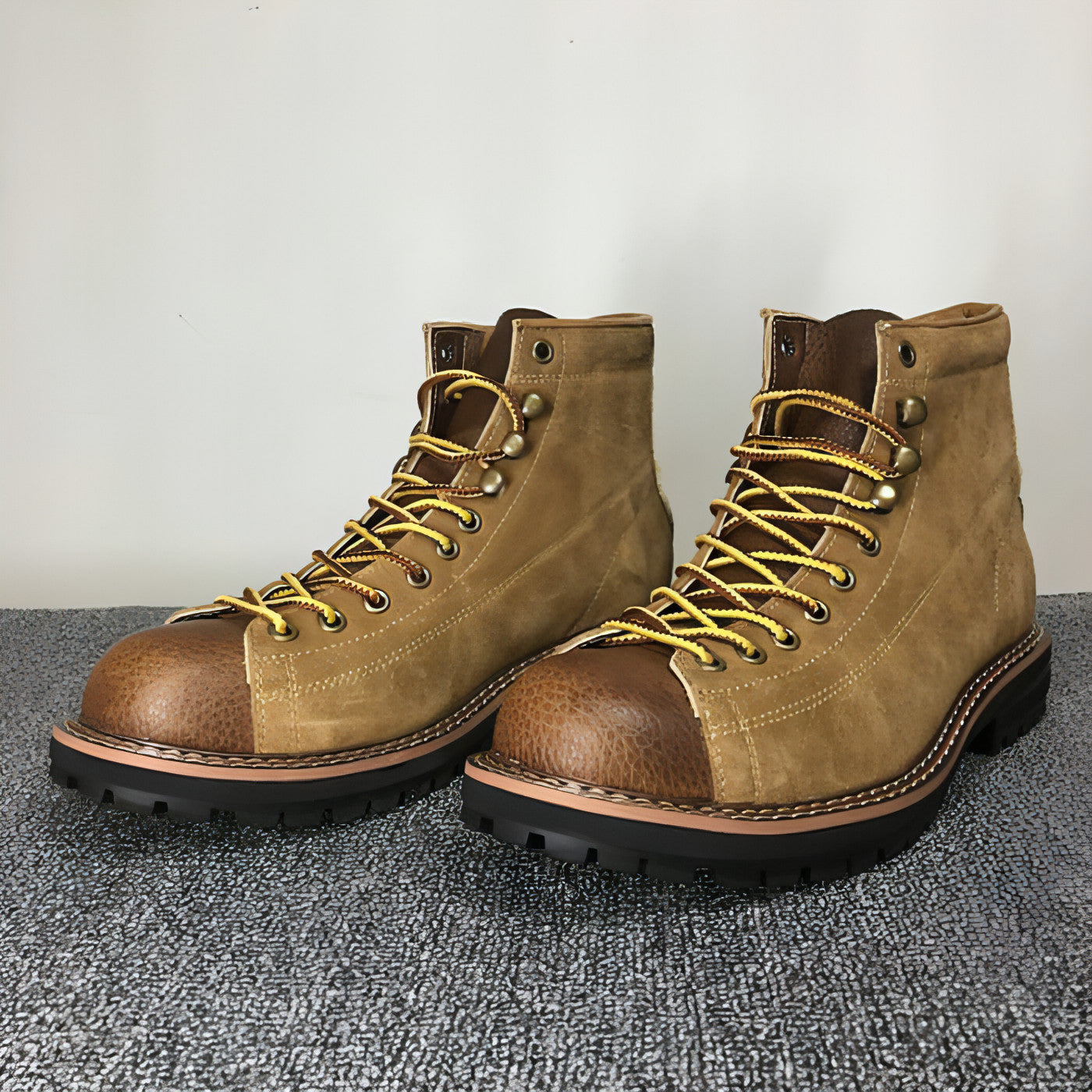 Paire de bottes en cuir marron à tige haute, lacets jaunes et semelle crantée