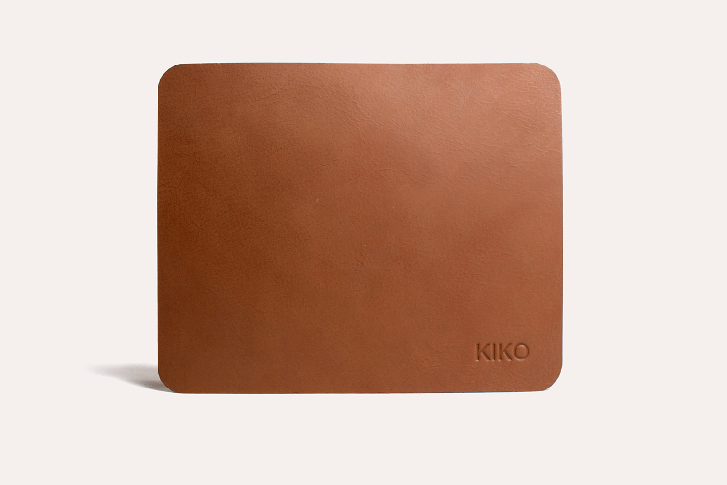 Tapis de souris en cuir brun, surface lisse, logo KIKO en bas à droite.