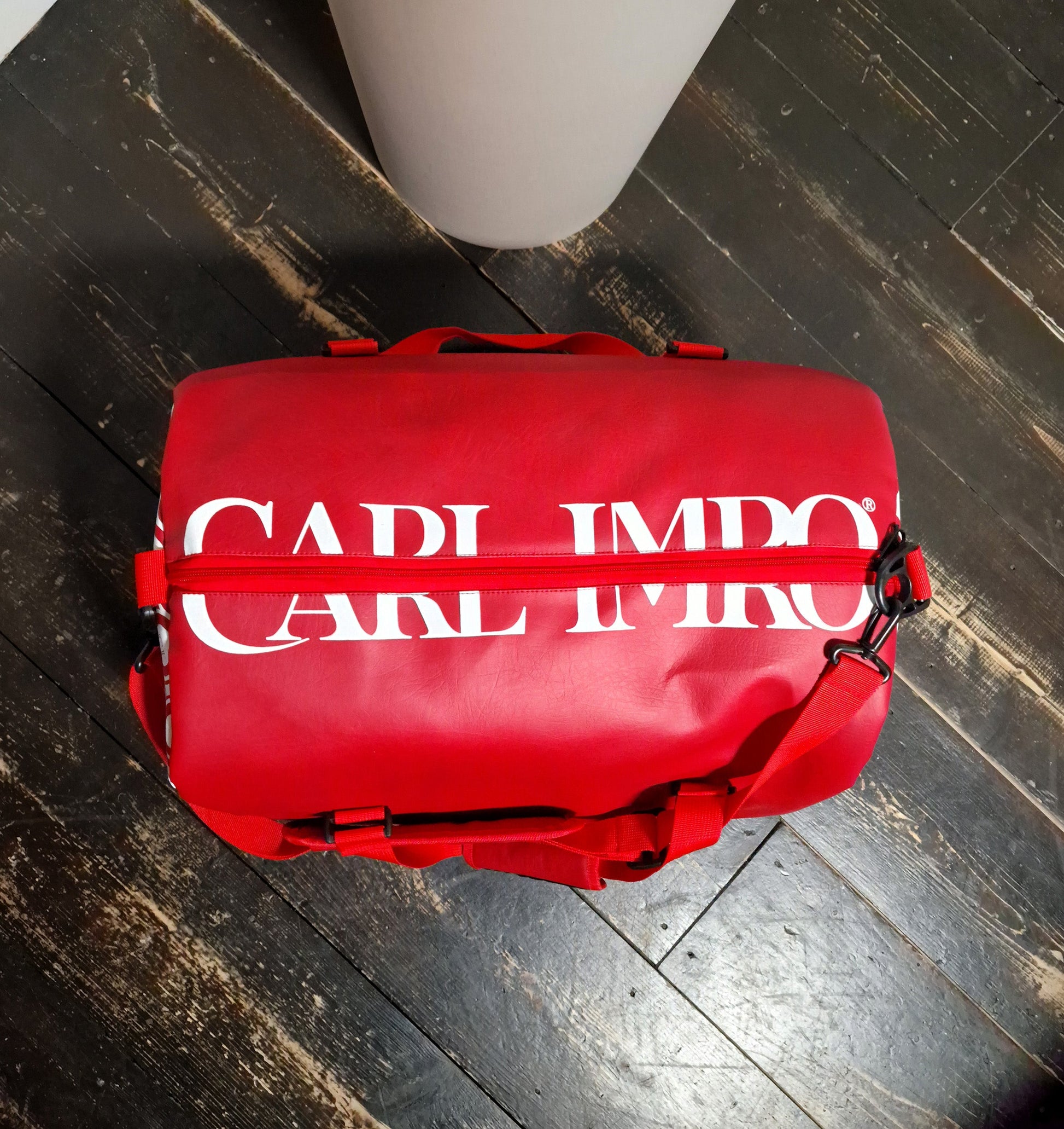 Sac en cuir rouge, vue du dessus avec fermeture, sangles et logo blanc