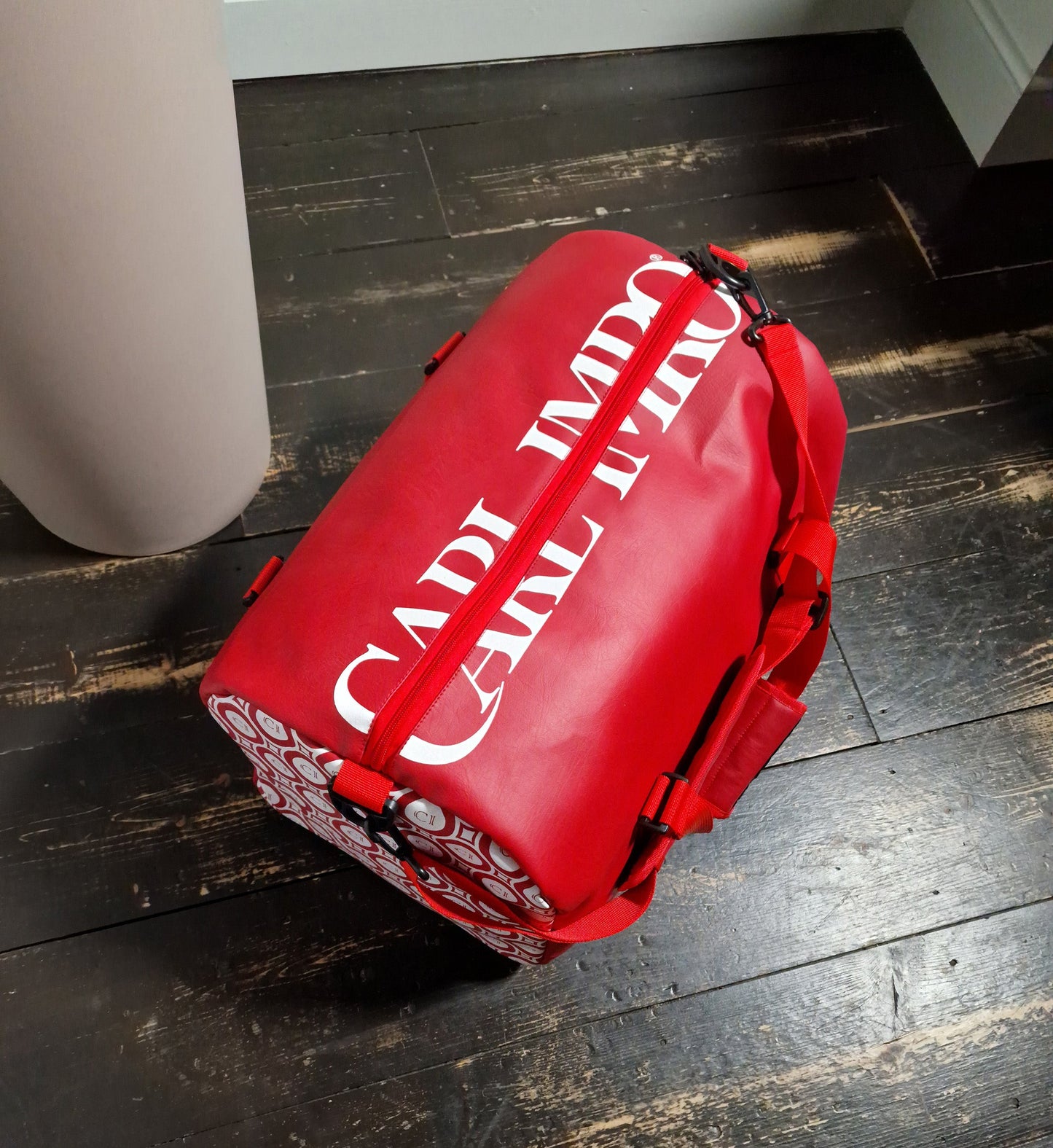 Sac bandoulière en cuir rouge avec fermeture et sangles, grand logo blanc