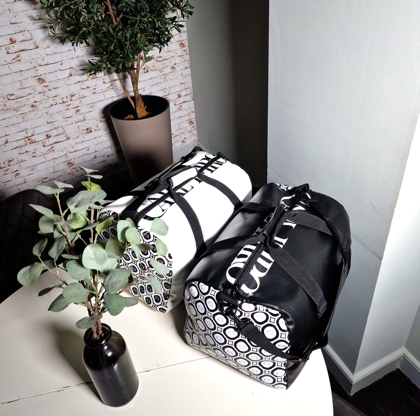Ensemble de sacs en cuir blanc et noir avec bandoulières; motifs de cercles et étiquette.