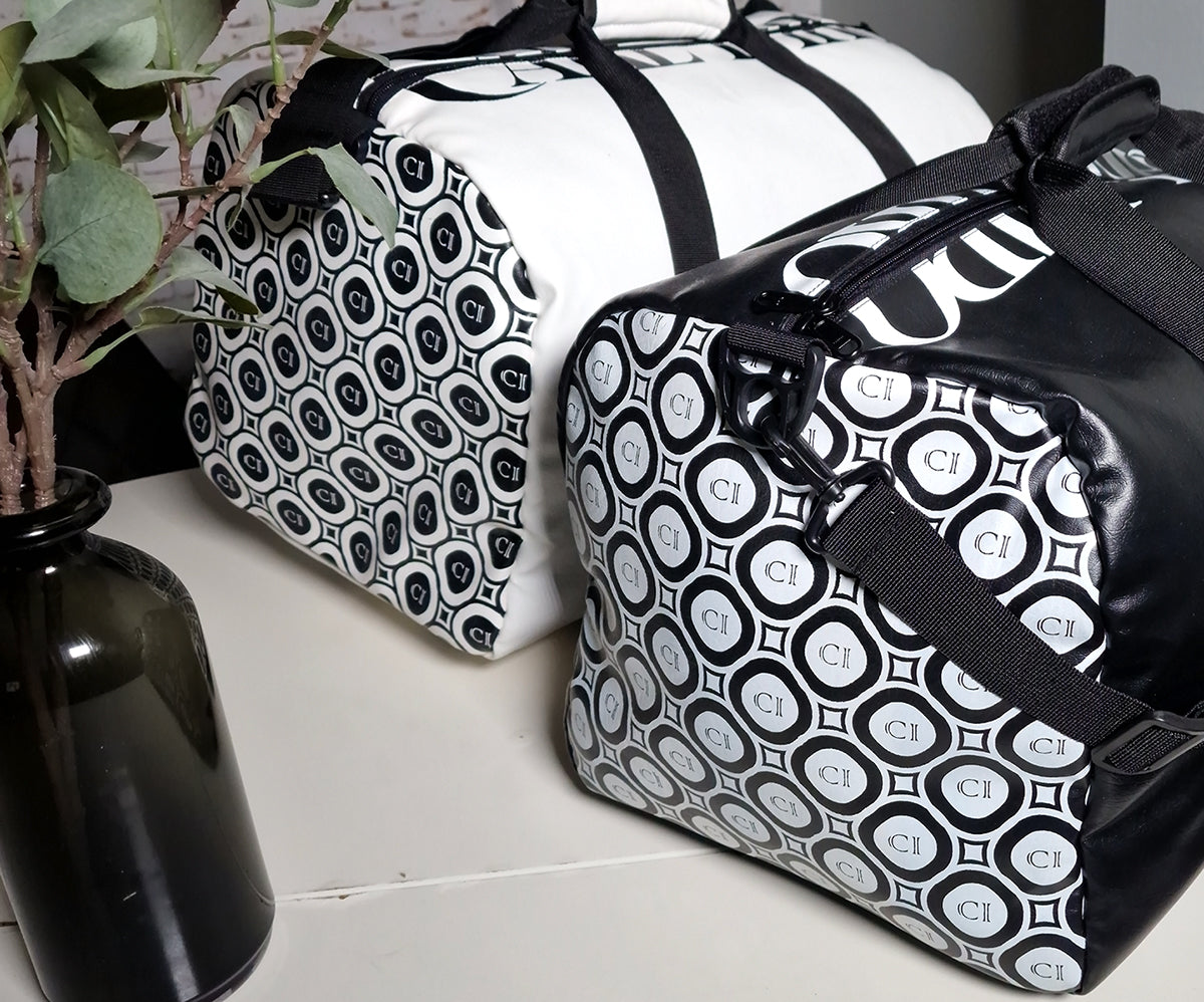 Sac en cuir blanc à motifs de cercles, bandoulière noire et fermeture avec anneau métallique.