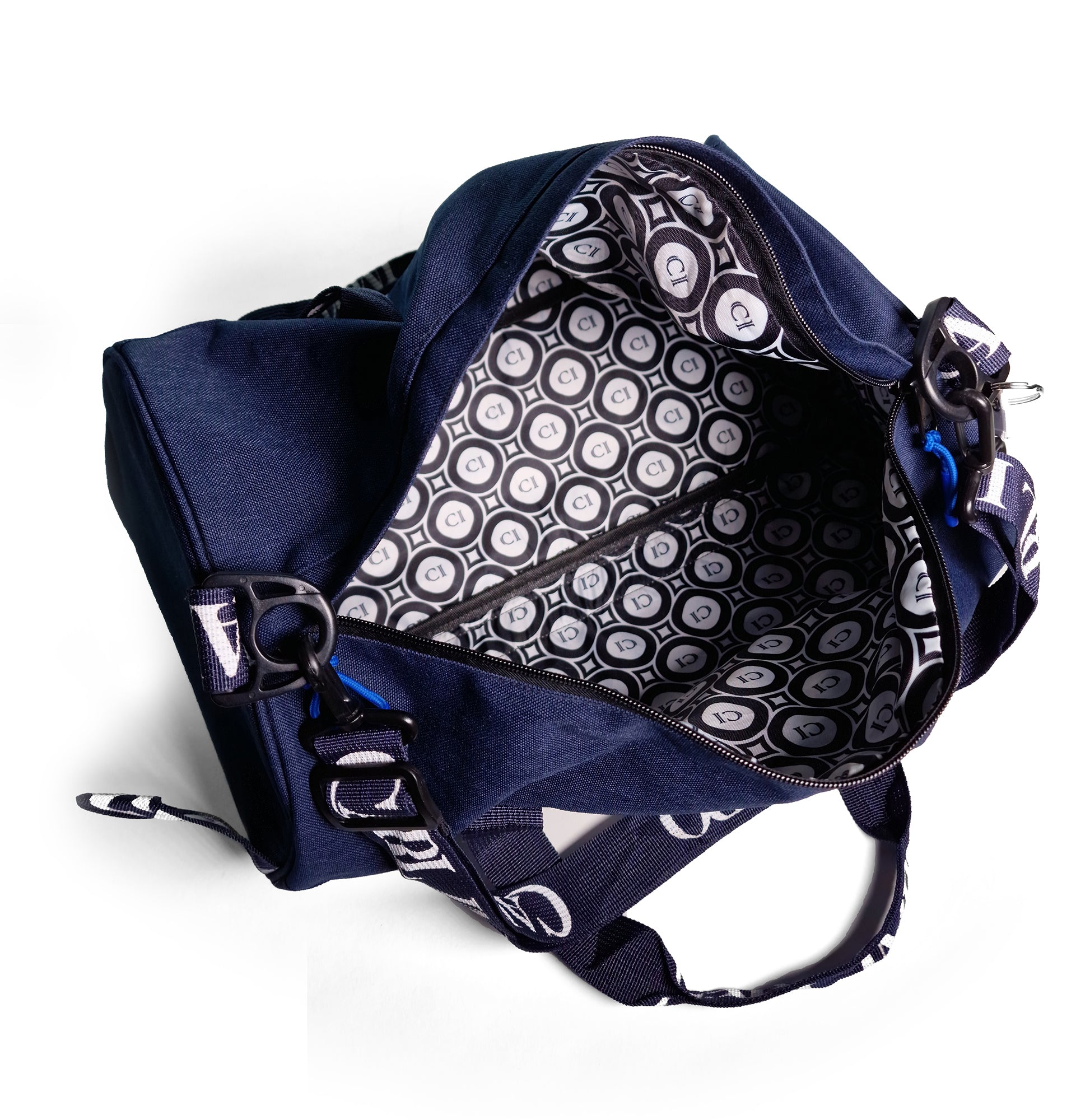 Sac duffel en denim bleu ouvert, doublure noire à motifs cercles et sangles.