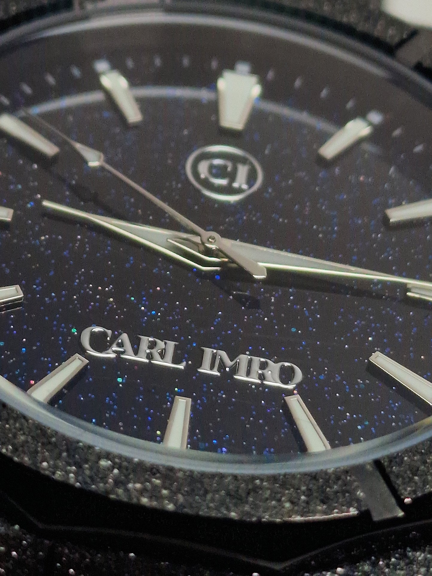 Cadran noir moucheté avec aiguilles fines et logo CRLi IMR au centre.