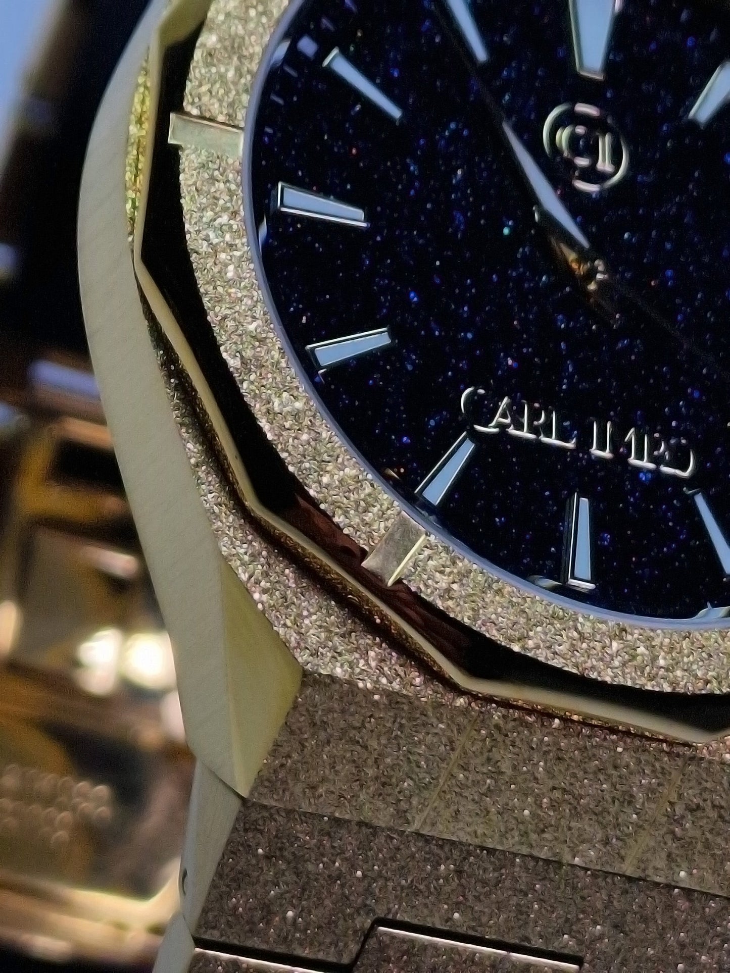 Montre homme, cadran bleu nuit pailleté avec logo et lunette strass dorée.