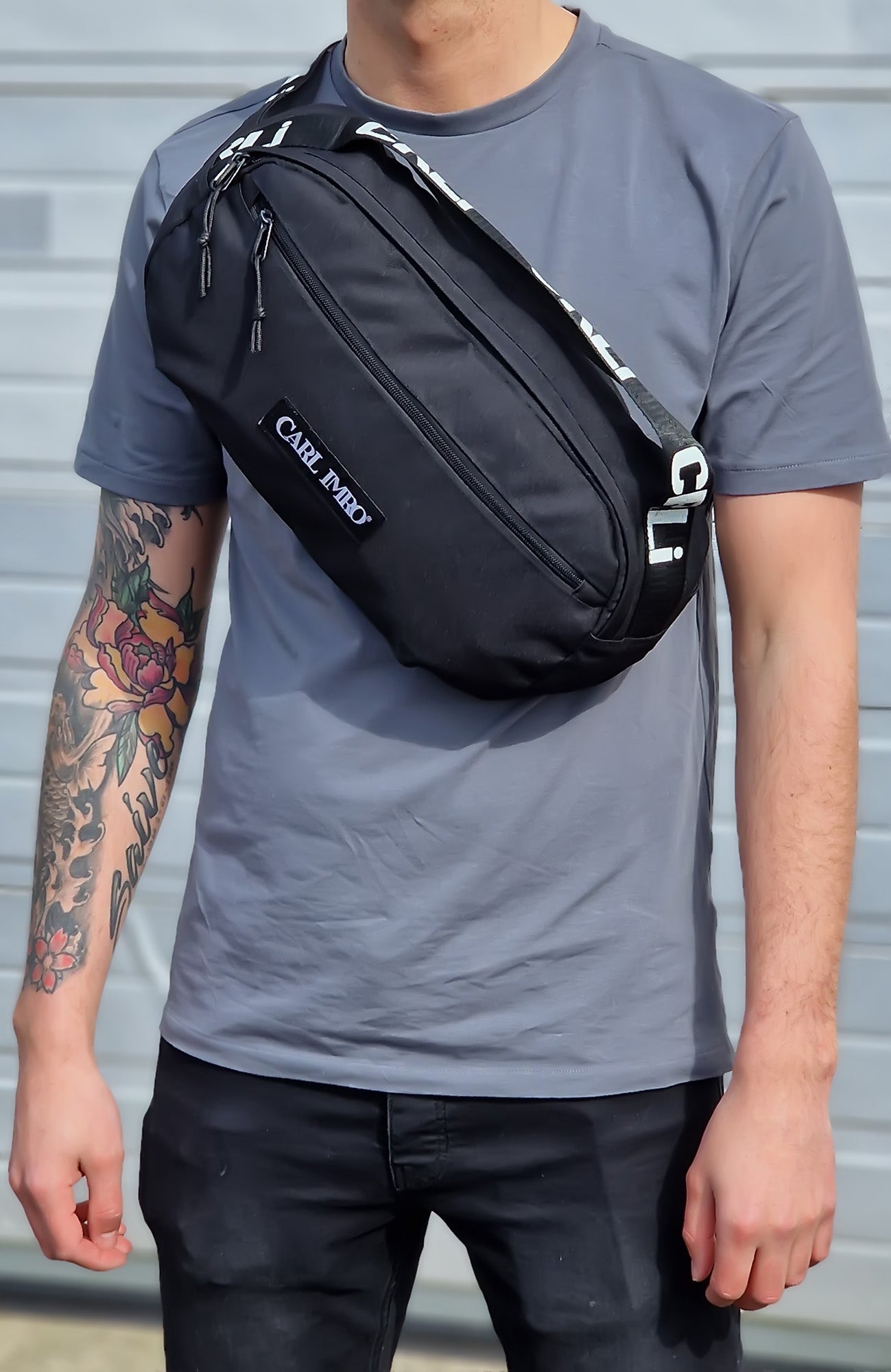 Sac bandoulière noir porté en bandoulière, fermeture zippée