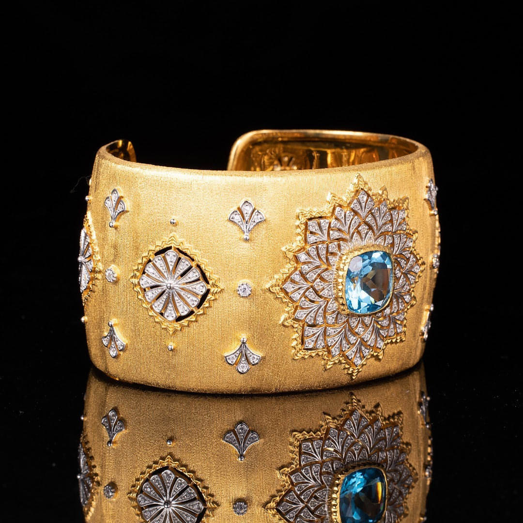 Bracelet manchette doré avec cabochon bleu entouré de motifs ciselés, 38 mm