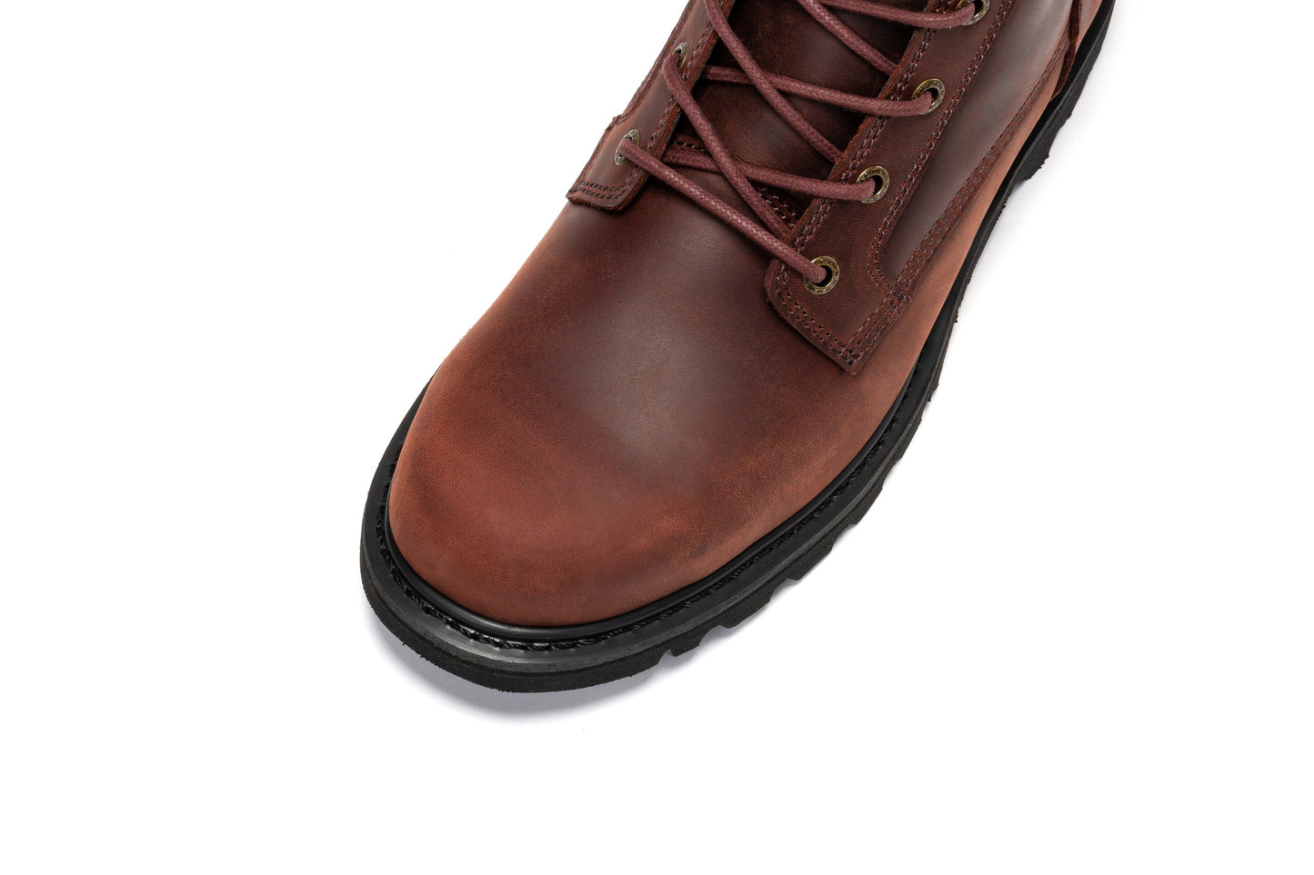 Botte en cuir marron, gros plan sur le dessus et les lacets, semelle noire