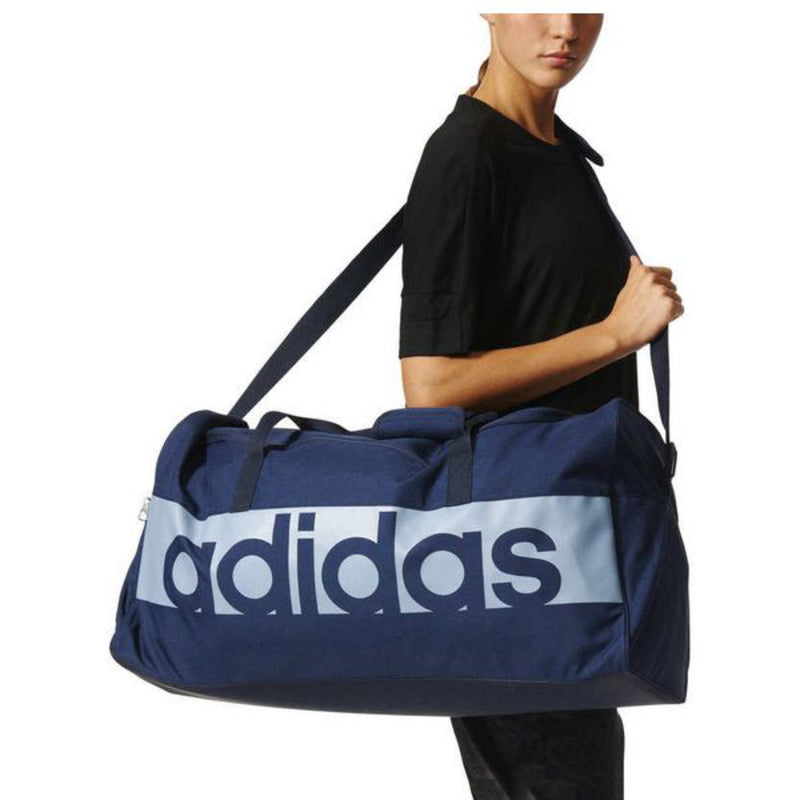 Sac de sport Adidas bleu avec logo blanc et bretelles, forme rectangulaire.