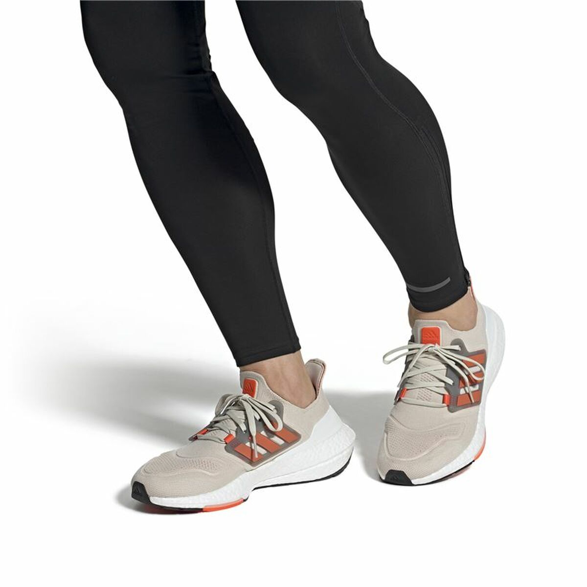Chaussures de running beige à lacets, bandes Adidas orange, pantalon noir