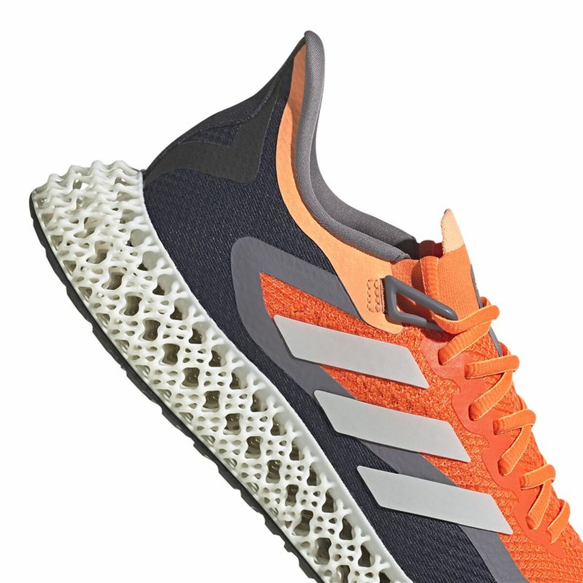 Chaussure de running Adidas : gros plan tige orange, lacets, bandes blanches et semelle ajourée.
