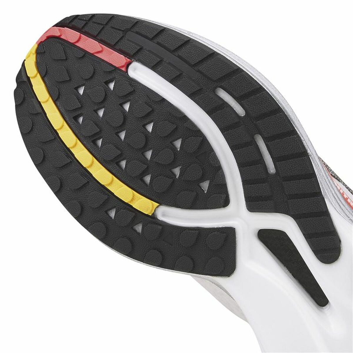 Semelle extérieure de chaussure Puma: crampons noirs, bord jaune et accent rouge.