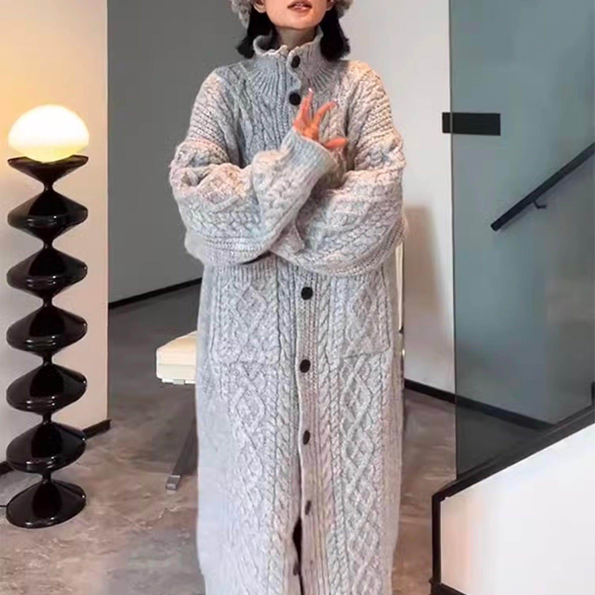 Cardigan long tricot bleu clair, boutons noirs, poches plaquées, col montant