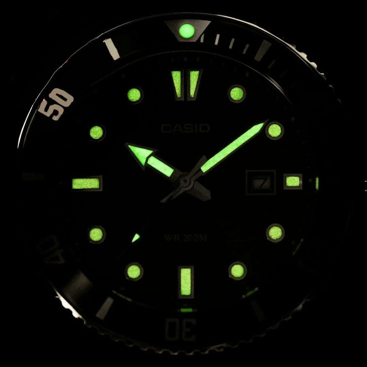 Montre diver cadran sombre avec index et aiguilles luminescents verts