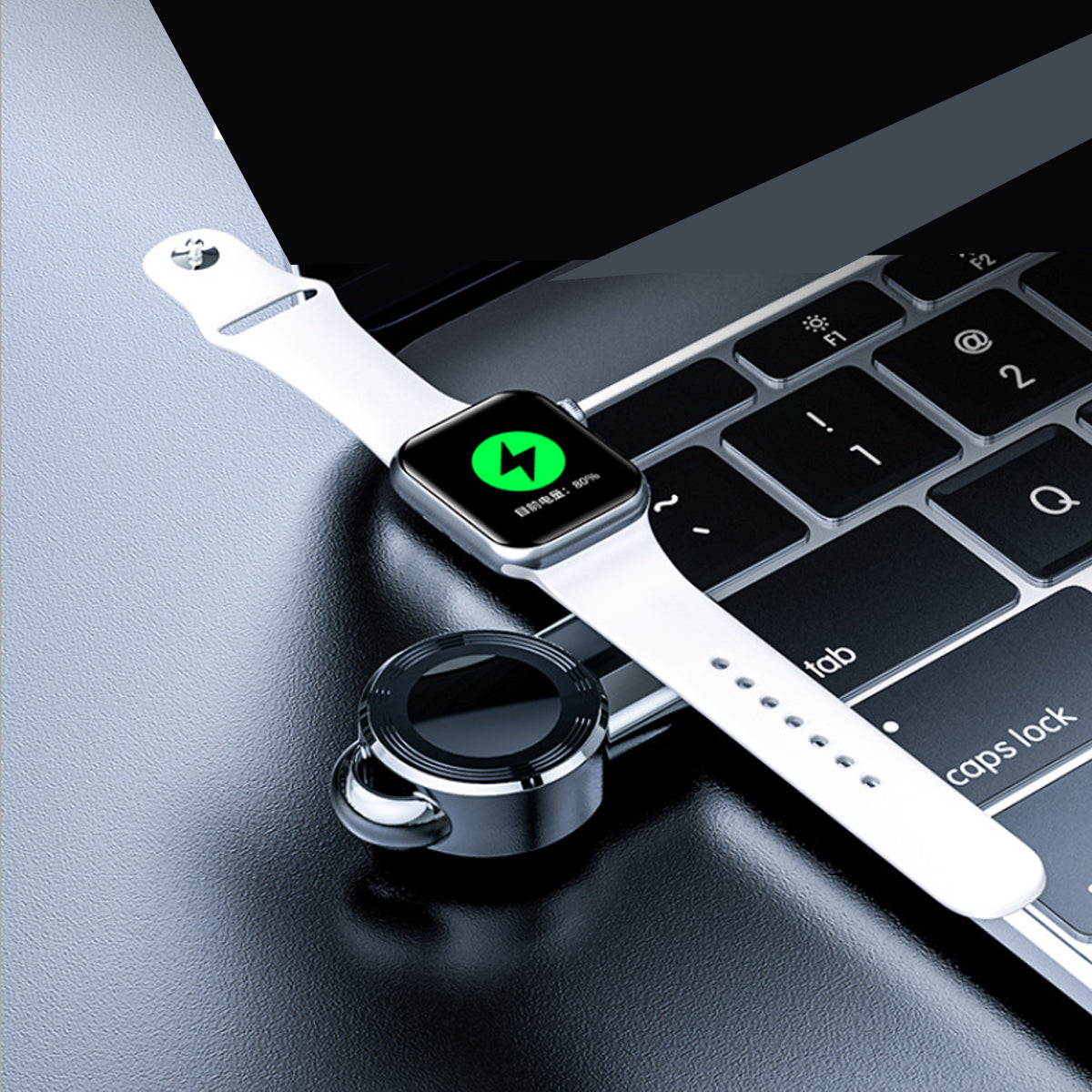 Chargeur USB compact noir sur bracelet blanc, branché près d’un clavier