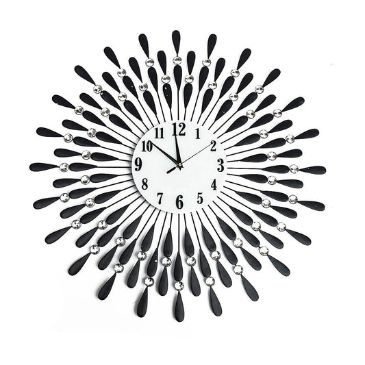 Horloge murale soleil 3D noire avec rayons métalliques argent et chiffres visibles.