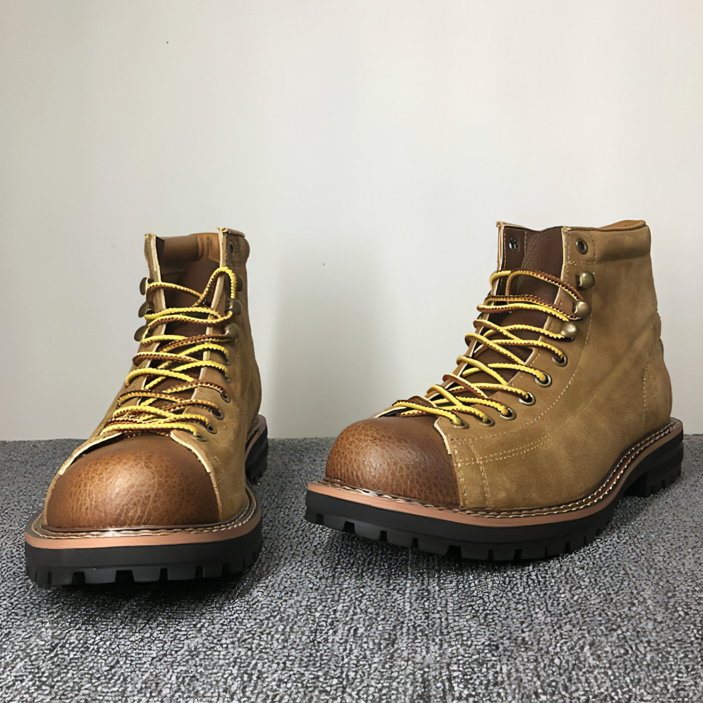 Paire de bottes à tige haute en cuir marron, lacets jaunes et semelle crantée