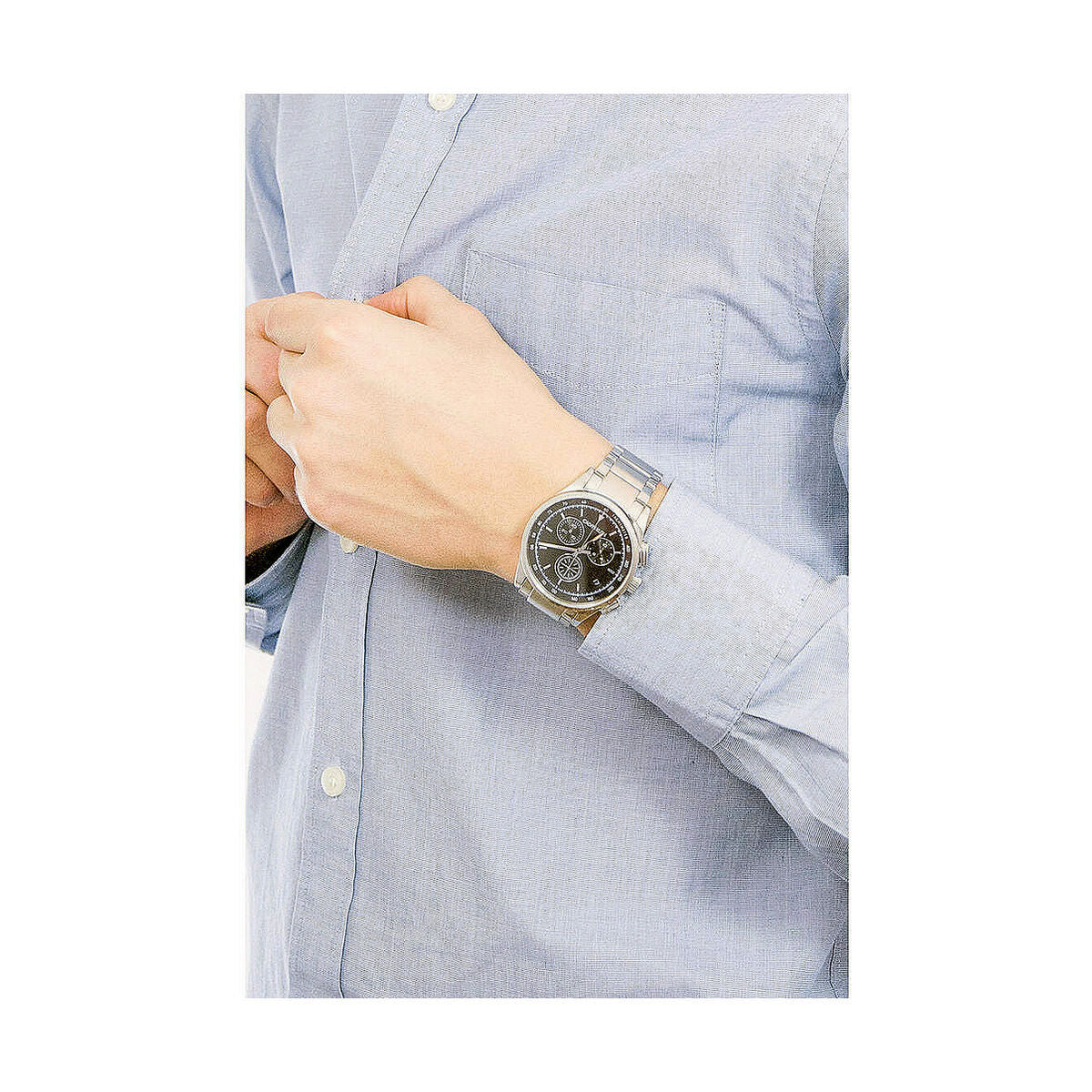 Montre en acier au poignet, cadran noir à trois compteurs, bracelet métal.