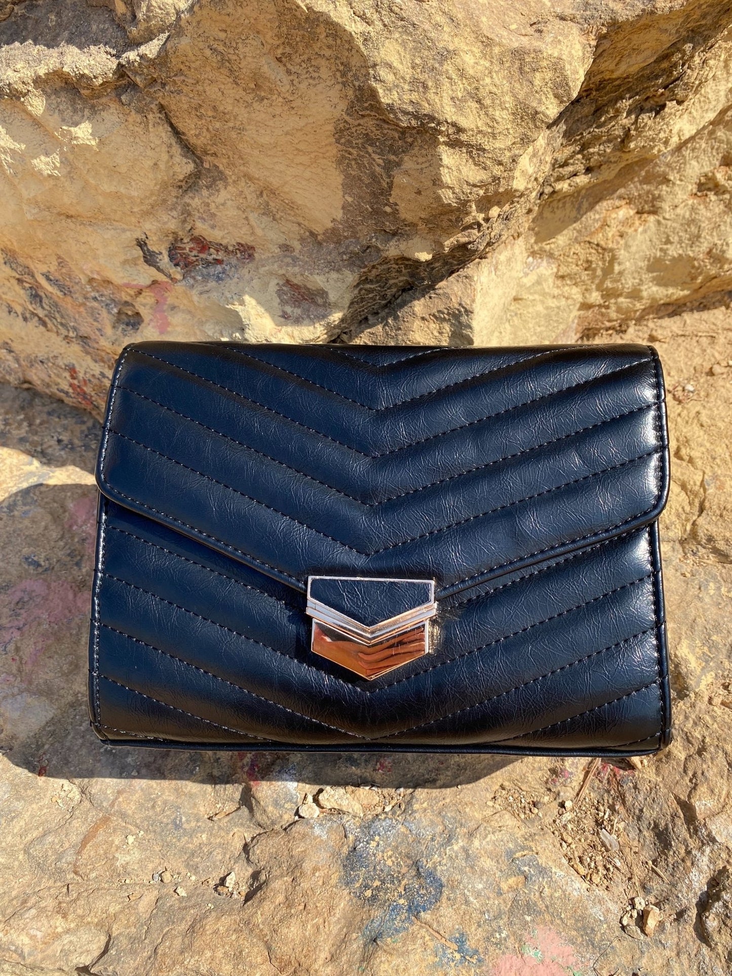 Sac bandoulière matelassé foncé, rabat avec fermoir métal doré, vue de face