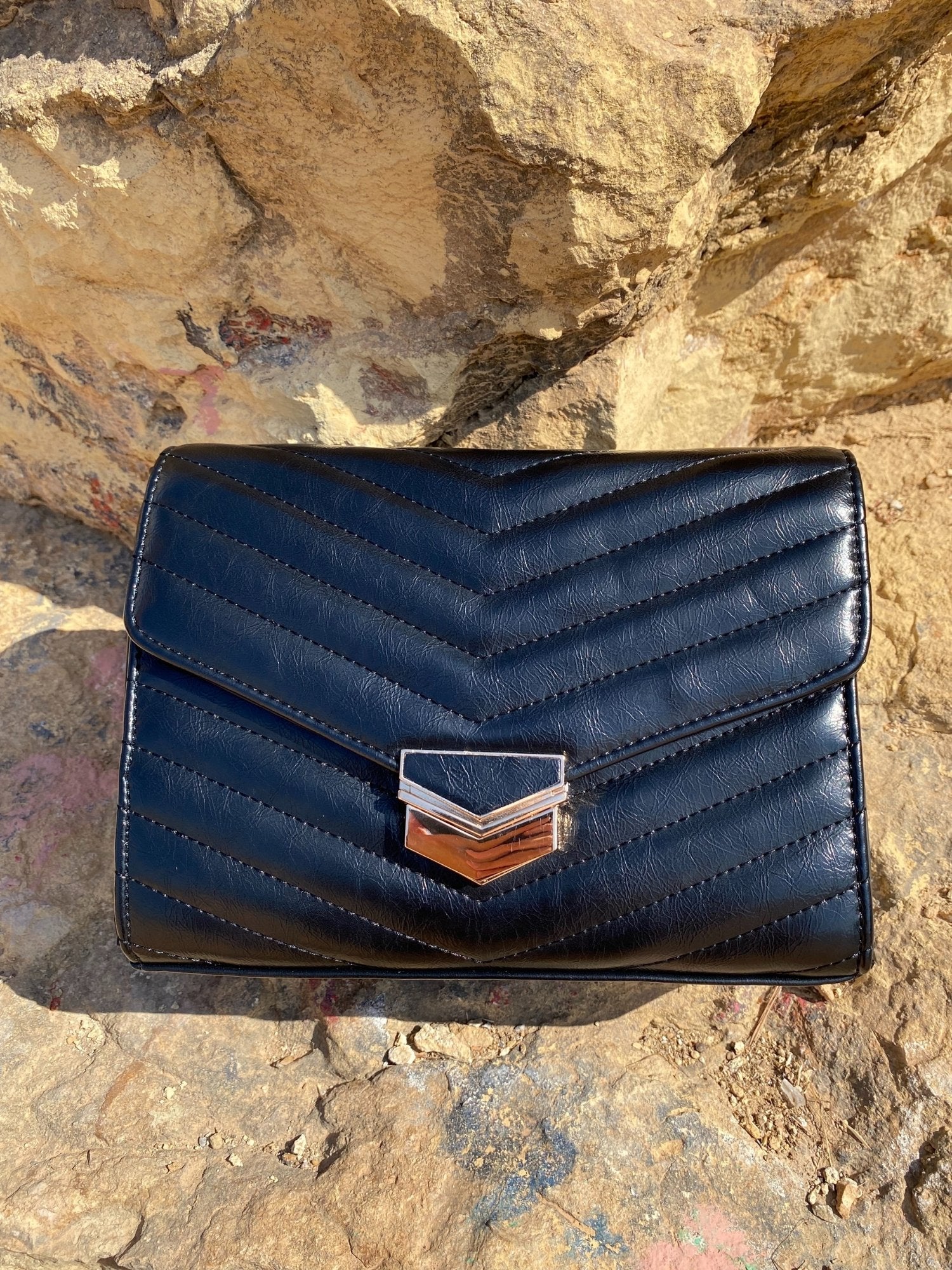 Sac bandoulière matelassé foncé, rabat avec fermoir métal doré, vue de face