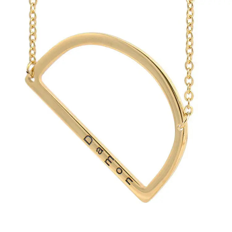 Collier en acier titane doré avec grand pendentif lettre évidée et chaîne.
