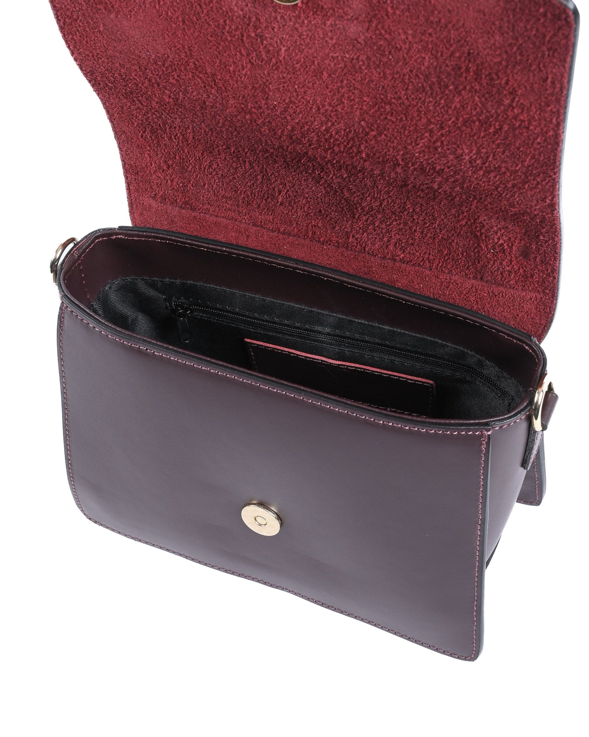Sac à main bordeaux ouvert : intérieur sombre, poche zippée et coutures sur le rabat.