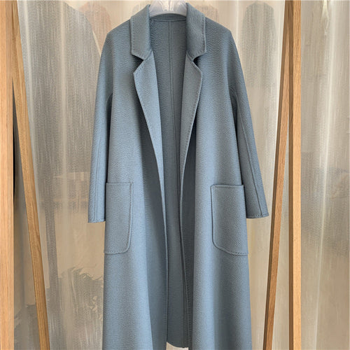 Manteau long en laine, couleur bleu clair, col à revers, poches plaquées, boutonnage