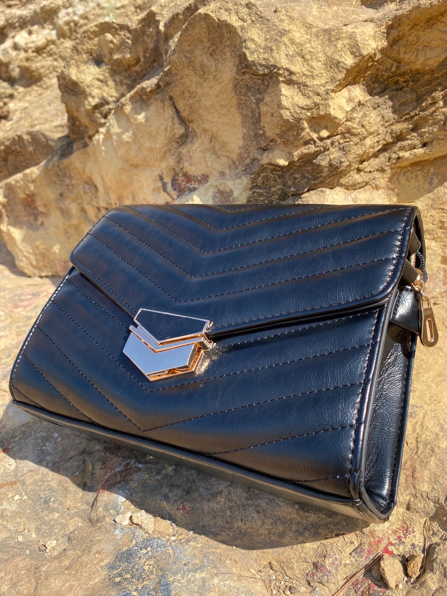 Sac bandoulière matelassé foncé avec rabat, fermoir métal doré, vue en biais