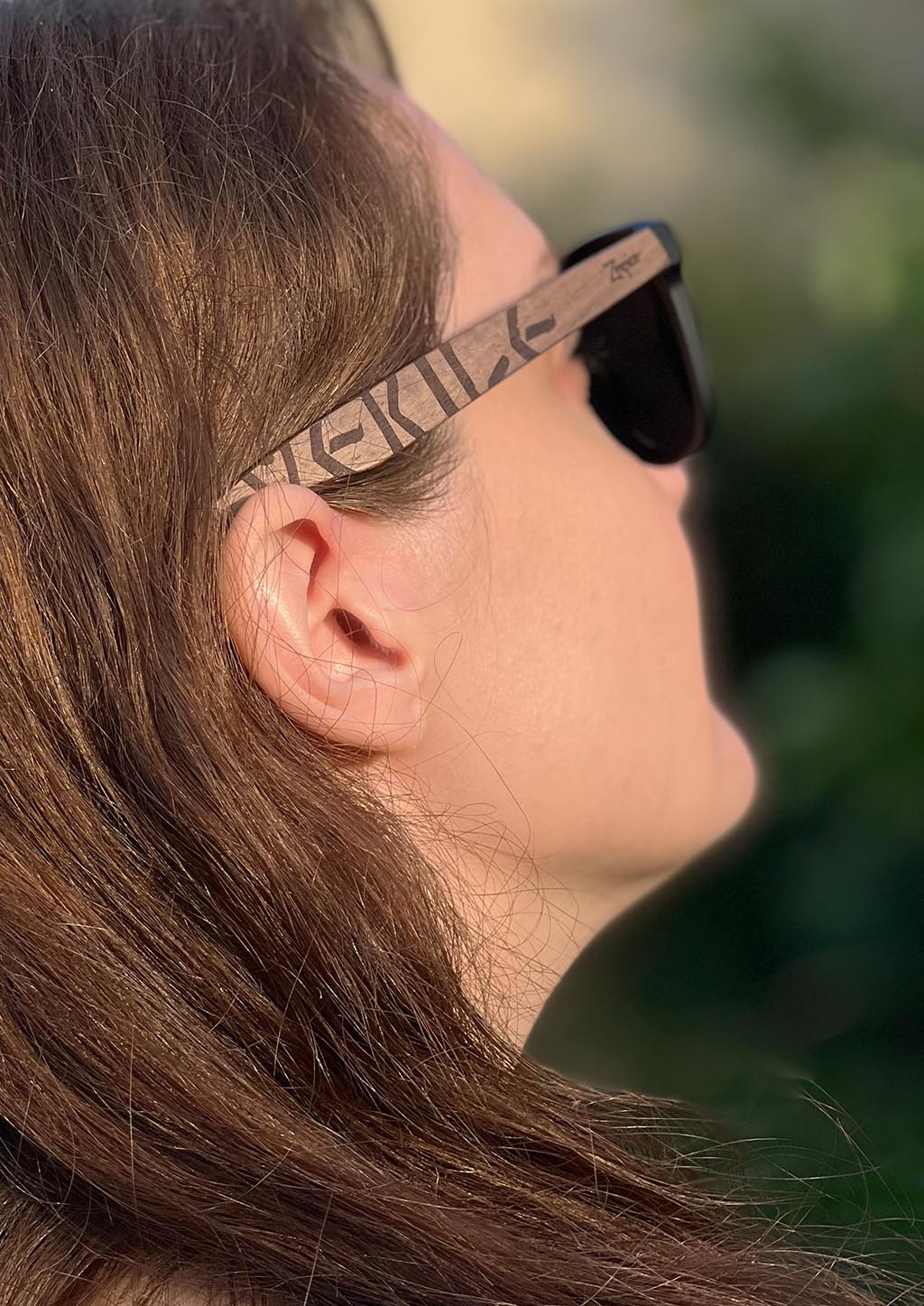 Lunettes Eyewood sur visage, monture noyer gravée et verres noirs polarisés