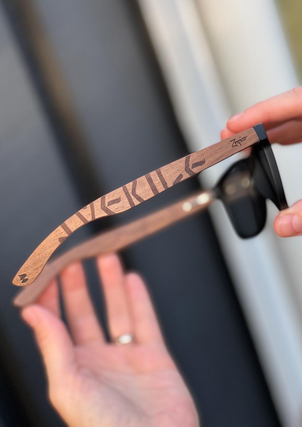 Lunettes Eyewood en noyer, détail de la branche gravée et verre noir polarisé