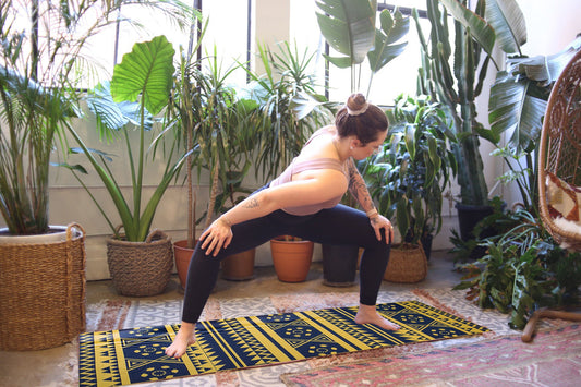 Tapis de yoga imprimé bleu marine sur sol, motifs géométriques, en situation d’exercice