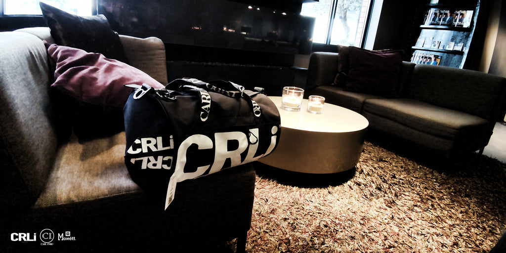 Sac de sport noir CRLi sur canapé, fermeture zippée et grand logo CRLi blanc