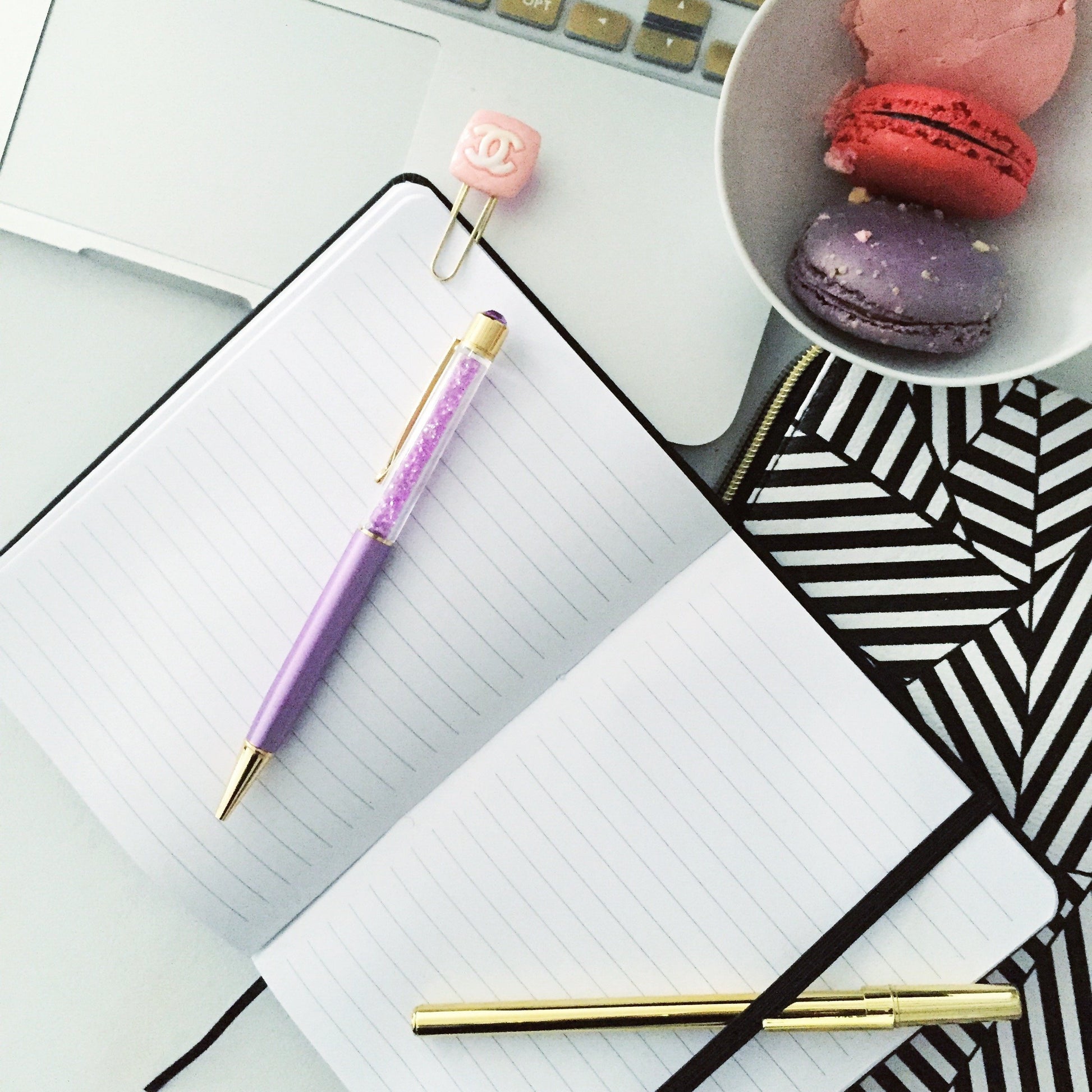 Carnet à lignes blanches, stylos doré et violet posés sur les pages