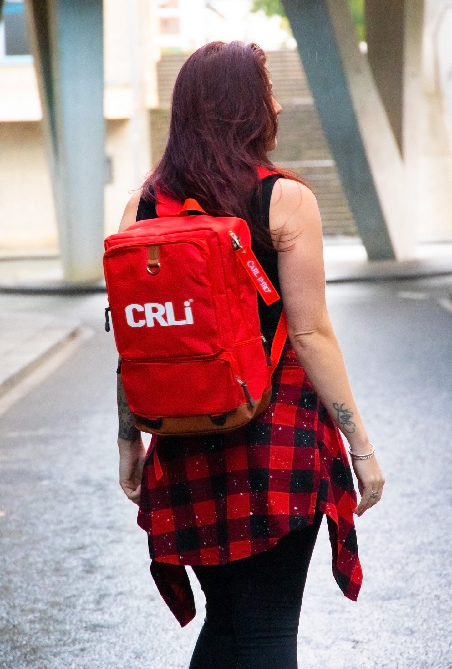 Sac à dos rouge CRLi, vue arrière, poche frontale zippée et attache latérale.