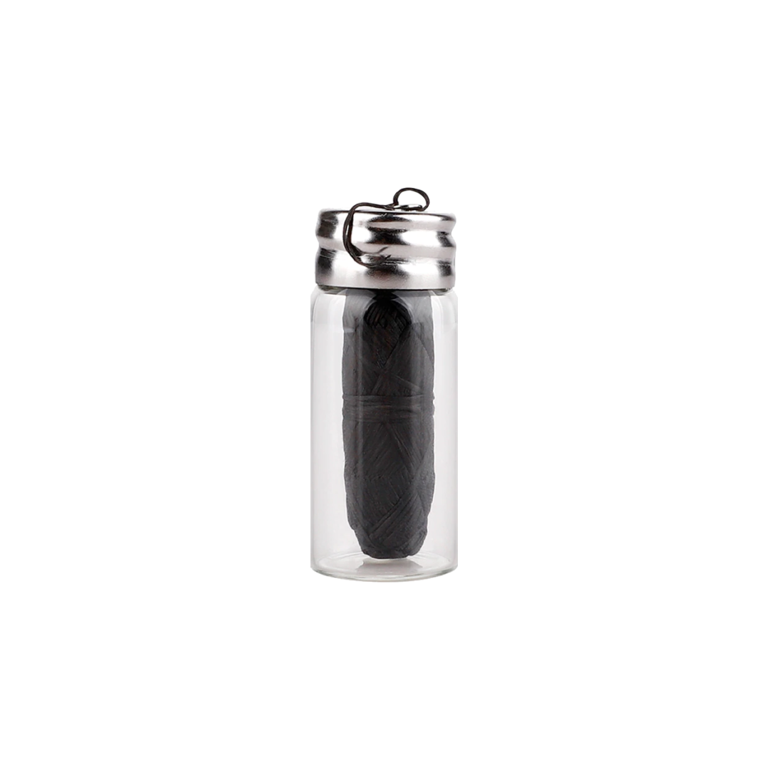 Flacon en verre avec bouchon métallique et accessoire noir à l’intérieur